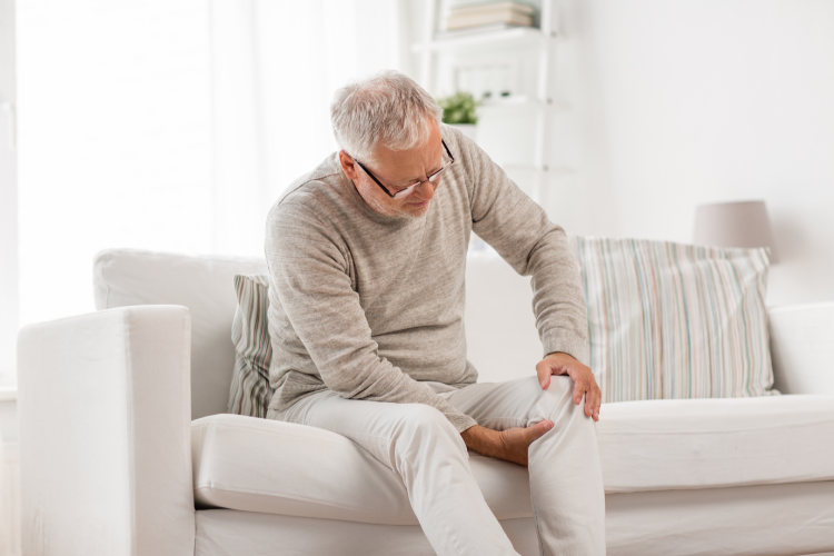 Elderly Man Seeking Knee Pain Relief at Home