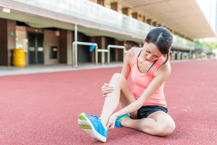 Female runner with ankle sprain on track field